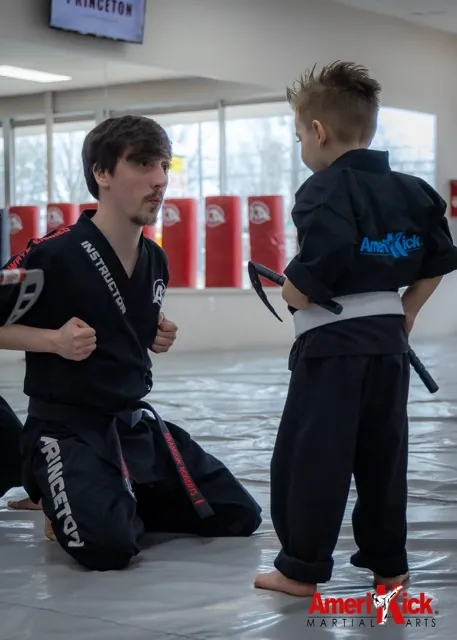 Young white-belt student training one-on-one with an instructor